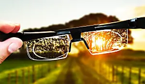 man holding Vision Pro and watching the sunset
